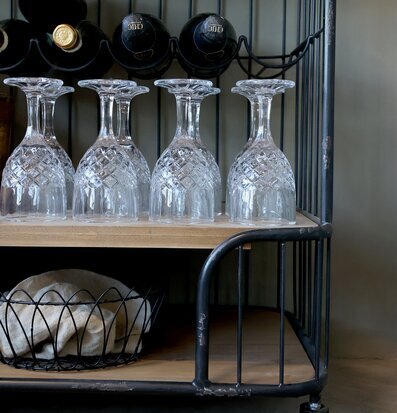 Bild av en industriell postvagn med vinhylla och glas