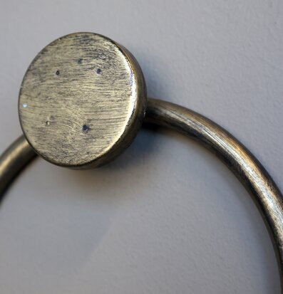 Bild av rund detalj i mässing på väggmonterat vinställ